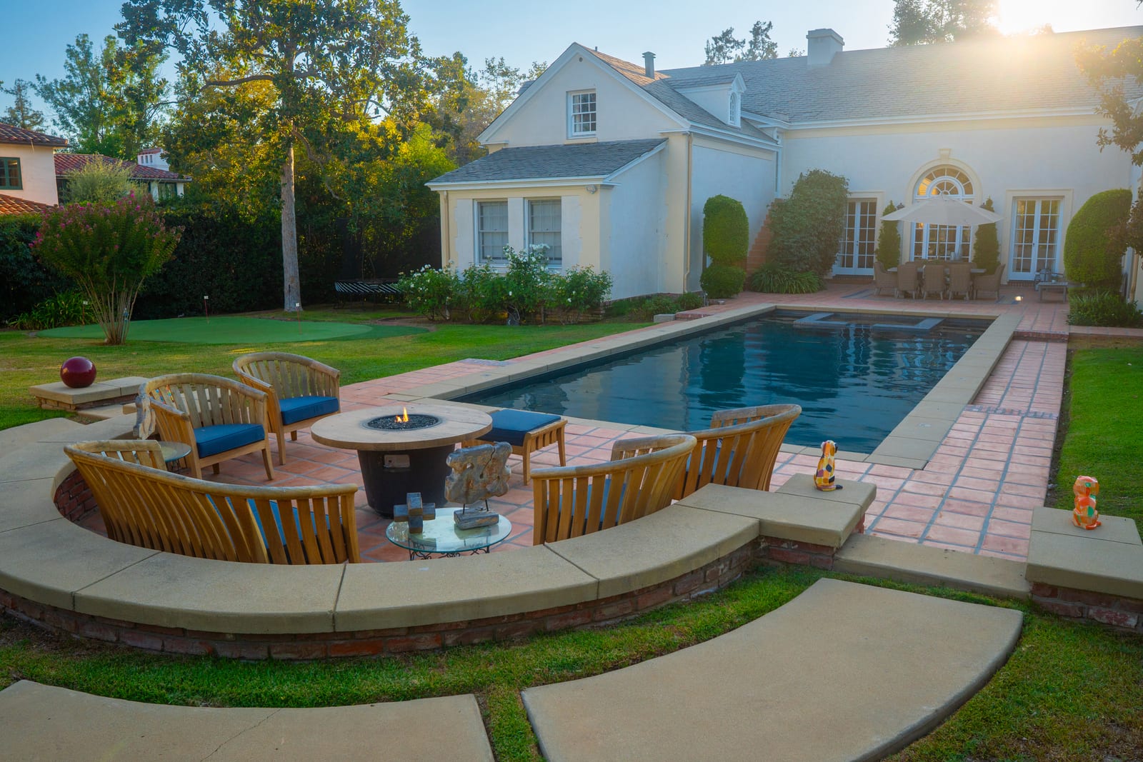 Spanish Estate backyard pool, putting green, and fire pit lounge