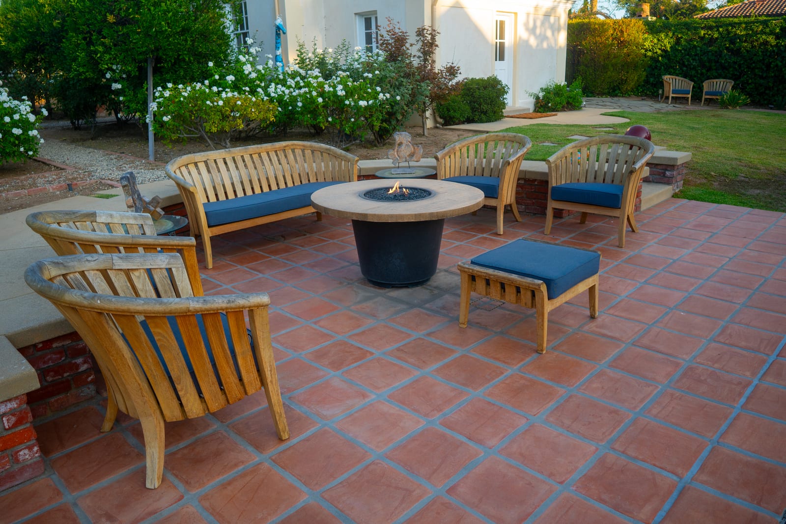 Spanish Estate terracotta patio with fire pit table and teak seating