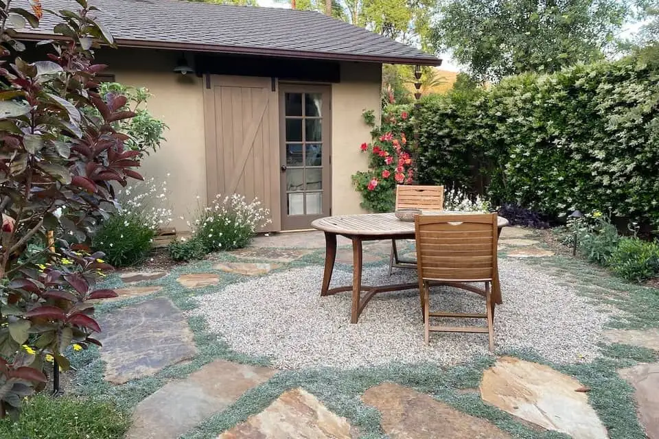 Table and chairs in front of a small building.