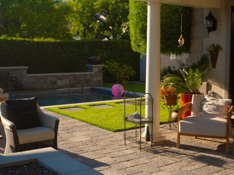Covered patio with columns overlooking the completed pool and landscape